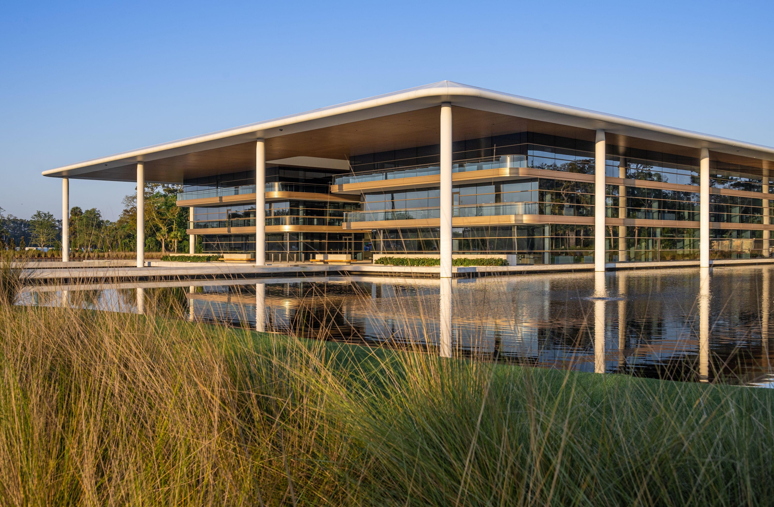 PGA Tour Headquarters across a pond, with its thin curved white roof canopy