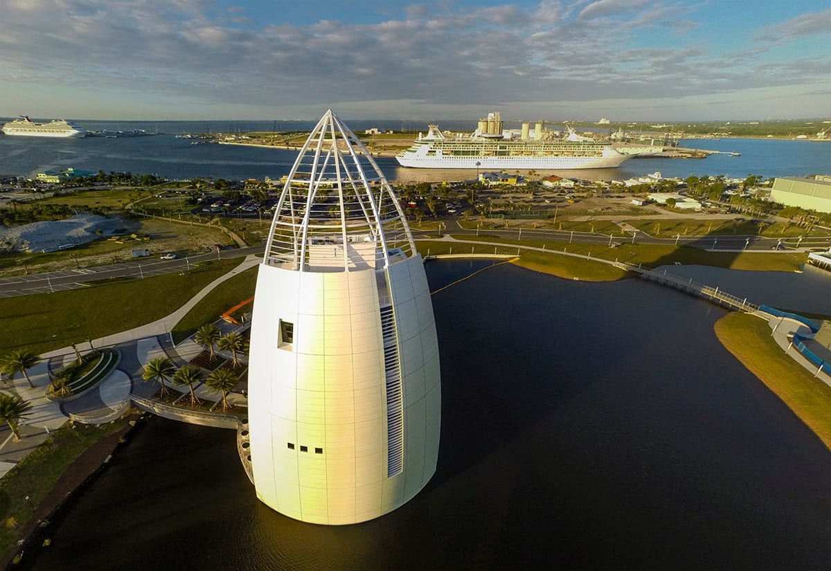 Aerial view of the Exploration Tower's curved white form beside the water