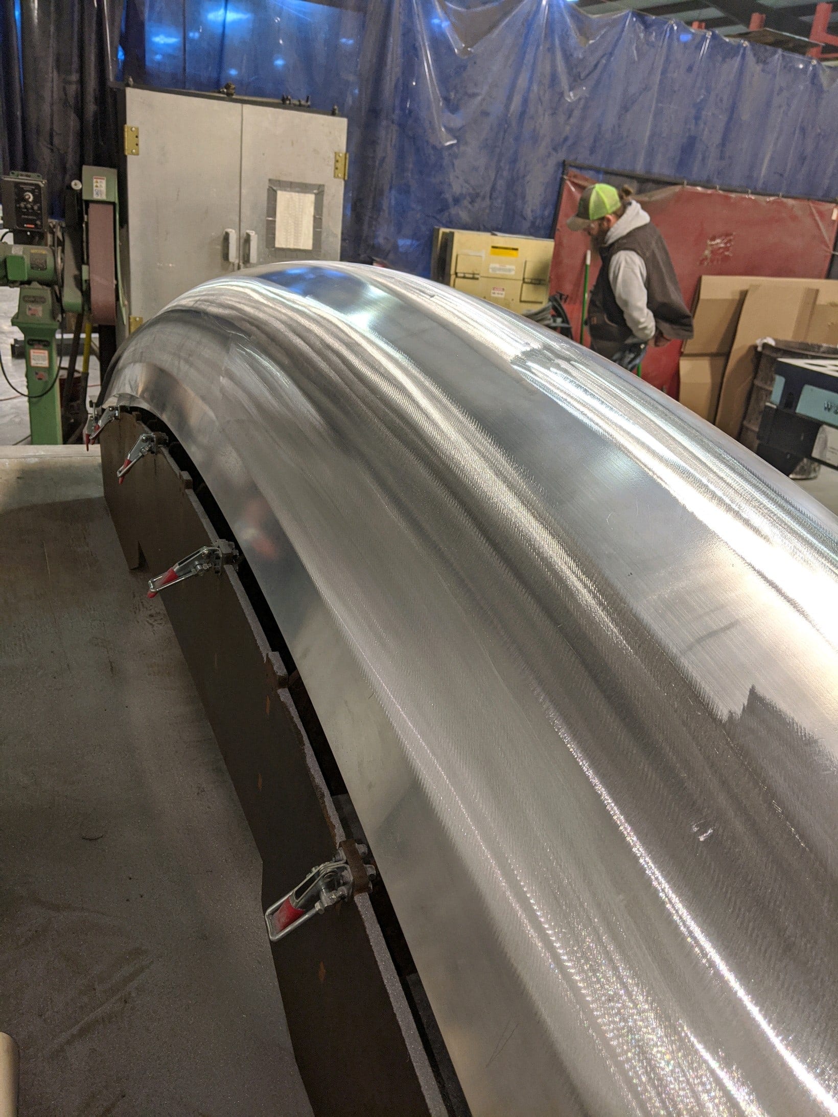 Mid-Am worker beside a curved canopy component in the shop