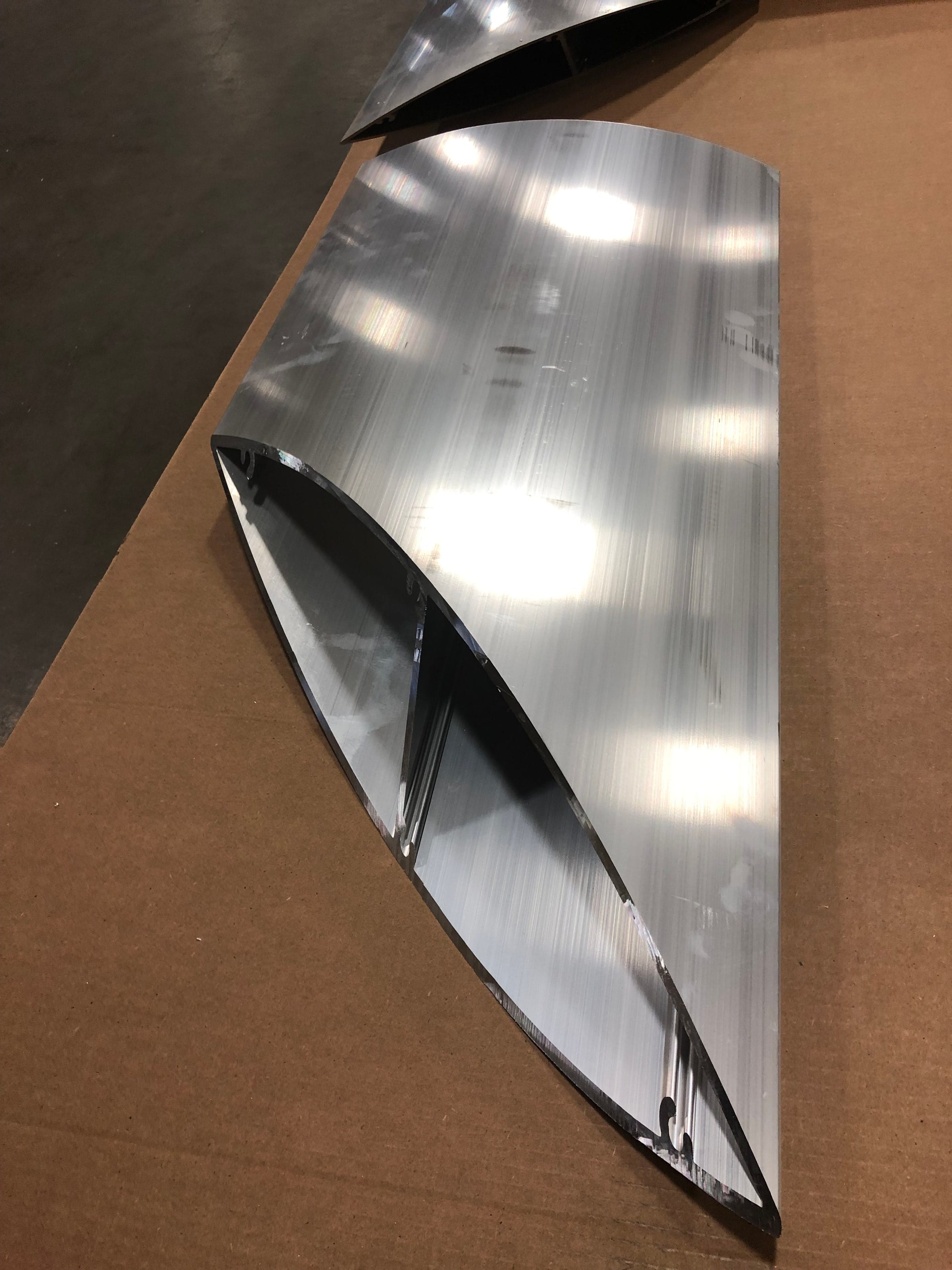 Close-up of a mitred, curved aluminum profile with a bright finish