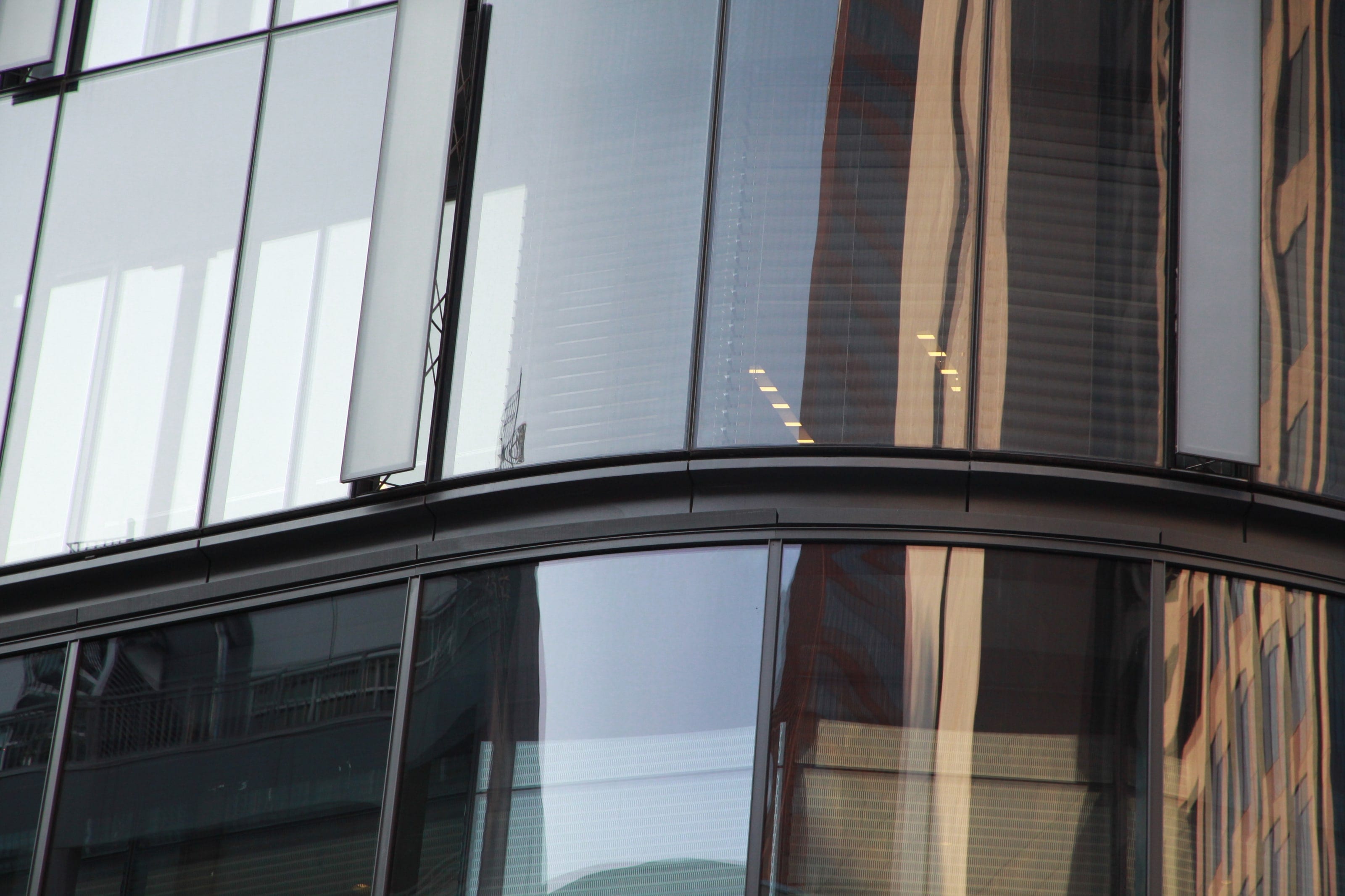 Curved glass at the base of the Tower at PNC Plaza, reflecting the street