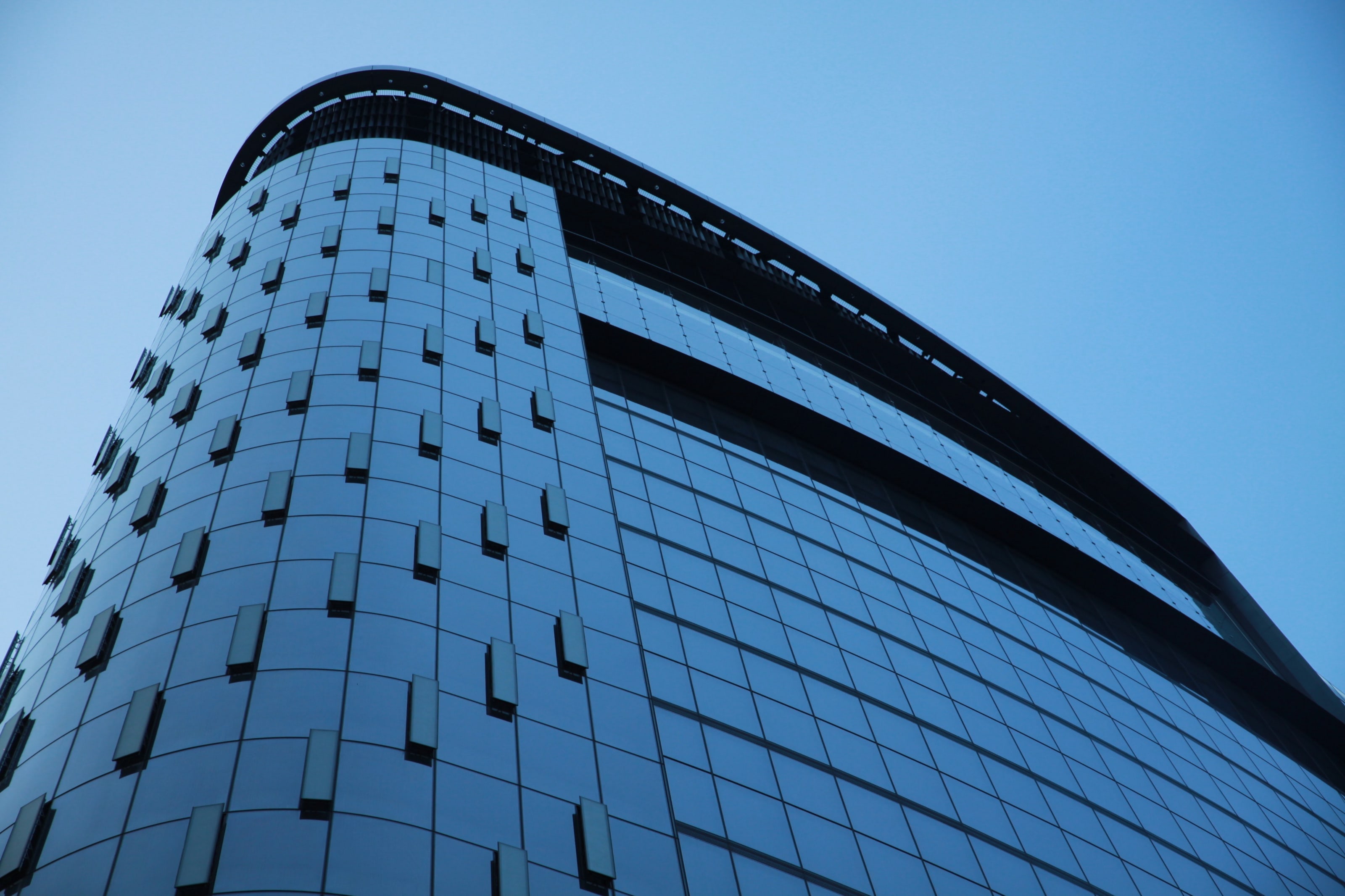 Curved corner of the Tower at PNC Plaza against a blue sky
