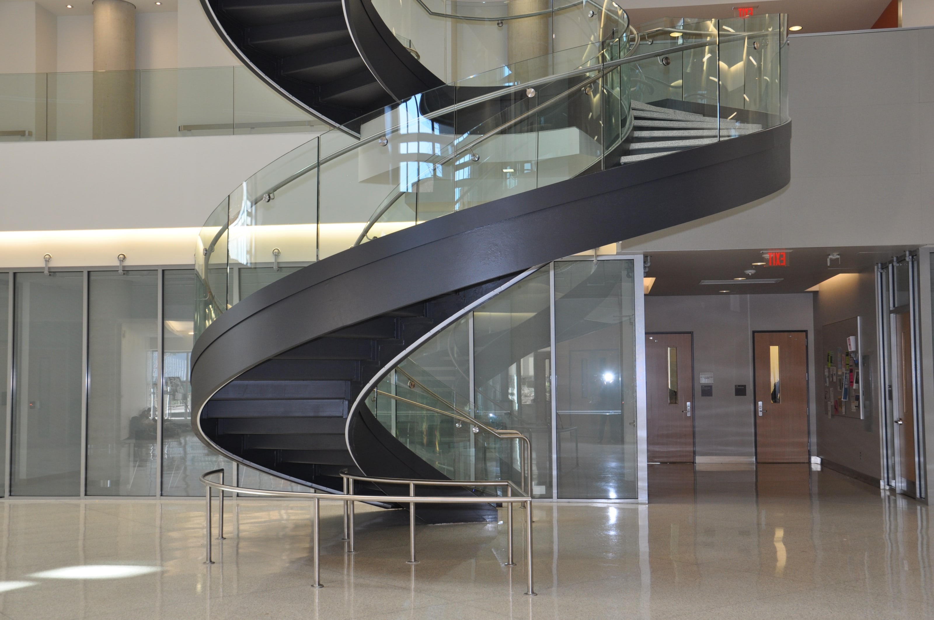 A helical staircase rising from the polished lobby floor at Drexel University